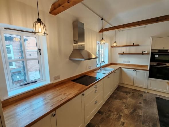 A painted Norfolk kitchen with solid oak worktops and open timber shelving